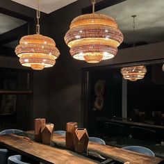 a wooden table topped with lots of blue chairs next to a large chandelier