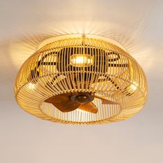 a fan that is hanging from the ceiling with light coming out of it's blades