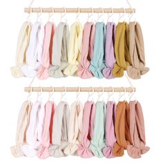 several different colors of scarves hanging on a clothes line with a wooden hanger