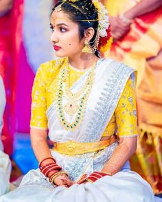 a woman in yellow and white dress sitting down