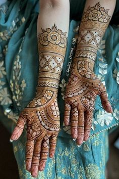 two hands with henna tattoos on them