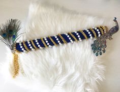 a blue and white beaded peacock garb with feathers on it's tail