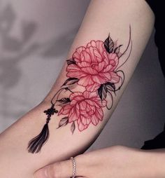 a woman's arm with flowers on it and a tatoo in the middle