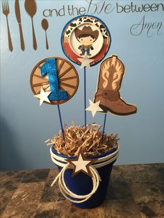 a cowboy themed centerpiece in a blue bucket with straw shavings and forks