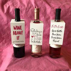 three bottles of wine sitting on top of a pink cloth covered tablecloth, one is labeled wine about it