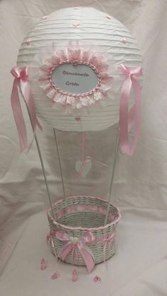 a white basket with pink bows and ribbon around it