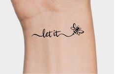 the word let it bee is written in cursive writing on a woman's wrist