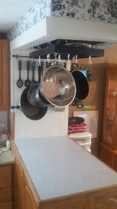 pots and pans hanging from the ceiling in a kitchen