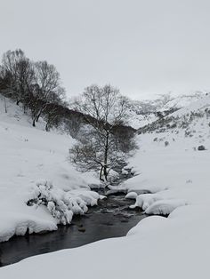 a small stream running through a snow covered landscape