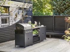 an outdoor bbq grill sitting on top of a wooden deck