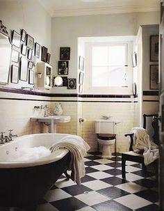 a bath room with a claw foot tub and a checkerboard floored floor