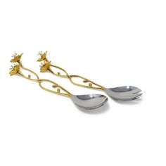 two silver spoons with gold flowers on them