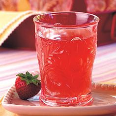 a strawberry drink in a glass on a plate