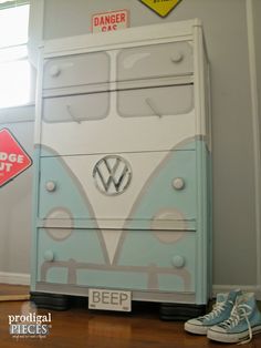 a blue and white van dresser sitting on top of a wooden floor next to a window