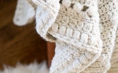 a white crocheted blanket on top of a wooden chair