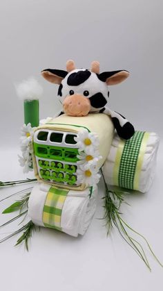 a stuffed cow sitting on top of a pile of toilet paper