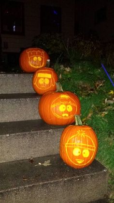 three pumpkins with faces carved into them sitting on the steps in front of a house