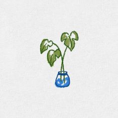 a blue vase with two green plants in it