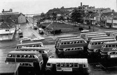 an old black and white photo of buses parked in a parking lot