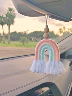 a car dashboard decoration with a rainbow hanging from it