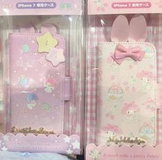 two pink hello kitty cell phones are in their packaging boxes, one is open and the other has a bow on it