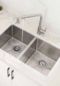 two stainless steel sinks in a white kitchen