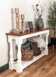 a white table with baskets and candles on it