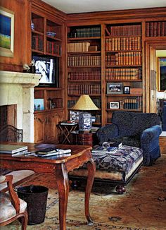 a living room filled with furniture and bookshelves covered in lots of bookcases