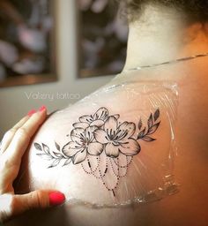 the back of a woman's shoulder with flowers on it