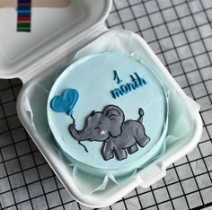 there is a cake in the shape of an elephant with a blue balloon on it