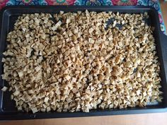 a pan filled with chopped up food on top of a wooden table next to a colorful cloth