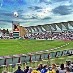 a large stadium filled with lots of people sitting on the bleachers watching a game