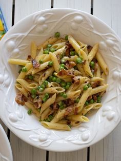 a white bowl filled with pasta and peas