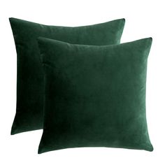 two dark green velvet pillows on a white background