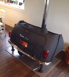 the back end of an old fashioned car on display in a room with wooden floors