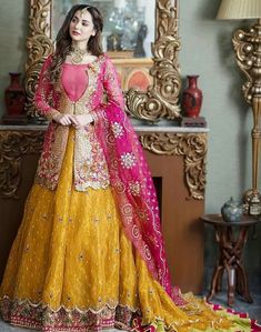 a woman in a yellow and pink lehenga