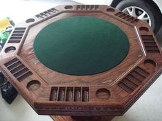 a wooden table with green top sitting next to a car