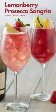 two wine glasses filled with liquid and strawberries next to a bottle of lemonberry prosecco sangria