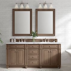 a bathroom with double sinks and two mirrors