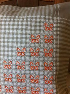 an orange and white pillow with bows on it