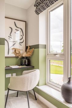 a green and white striped room with a chair, window sill, and painting on the wall