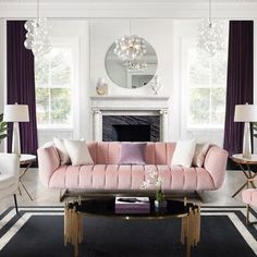 a living room with pink couches and chairs in front of a mirror on the wall