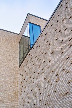 the side of a brick building with a clock on it's face and windows