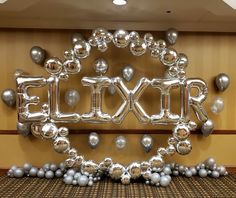 a large balloon sign that says lucky in front of balloons and silver balls on the floor