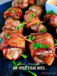 bacon wrapped air fryer steak bites on a blue plate with parsley garnish