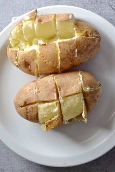 two pieces of bread on a plate with butter and potatoes cut in half to look like they have been baked