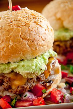 a cheeseburger with lettuce, tomato and onion on a plate next to french fries