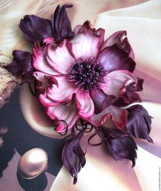 a bouquet of purple flowers sitting on top of a white table cloth next to an egg