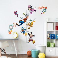 a child's room with mickey mouse and friends on the growth chart wall decals