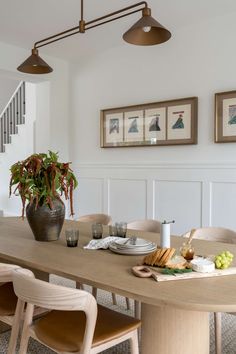 a dining room table with chairs and plates on it